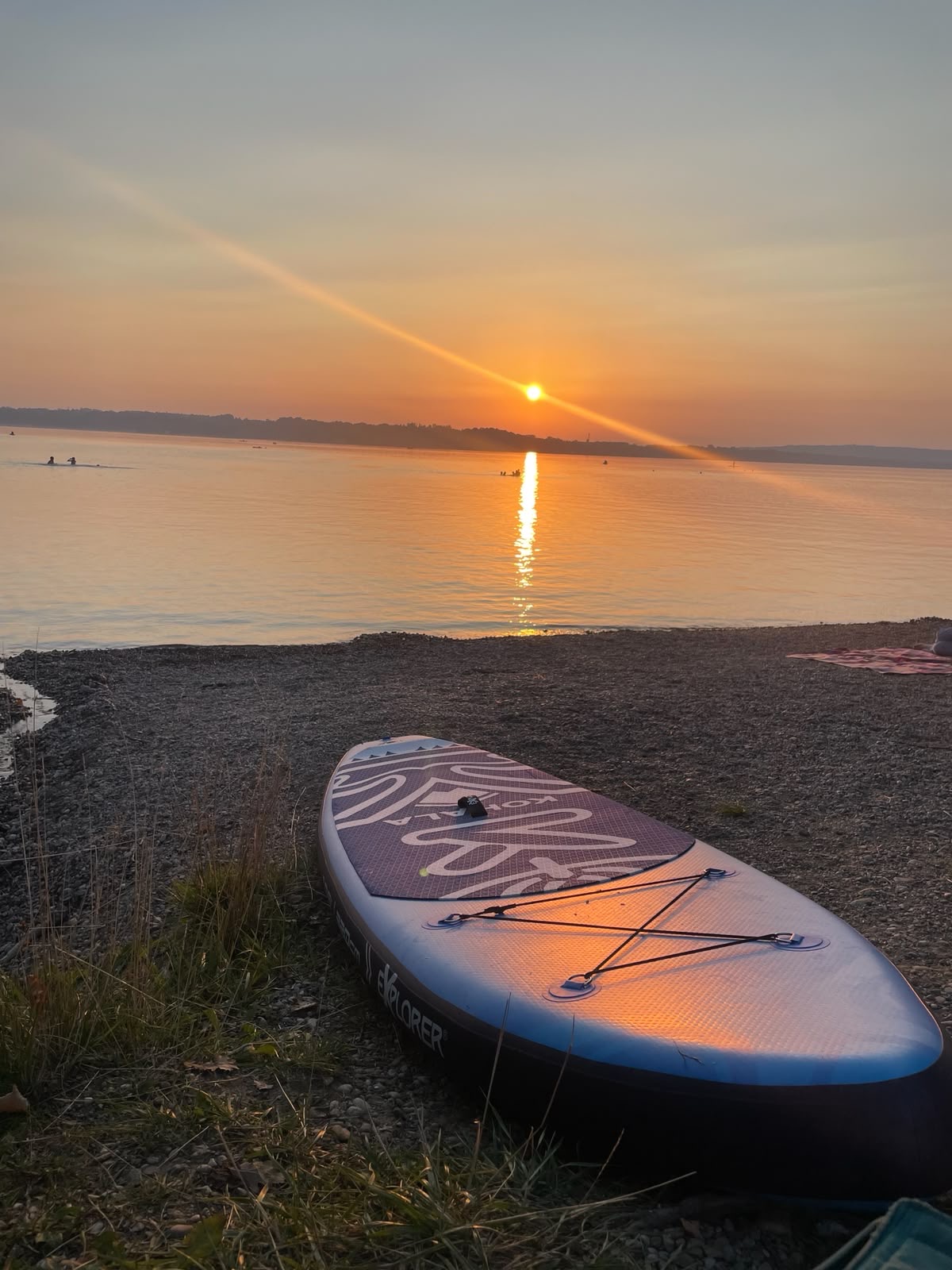 SUP am See bei Sonnenuntergang